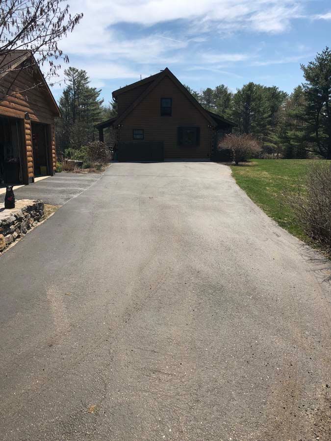 A driveway leading to a large house with a garage.