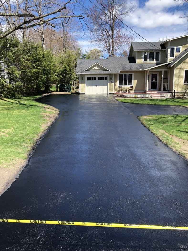 A house with a large driveway leading to it.