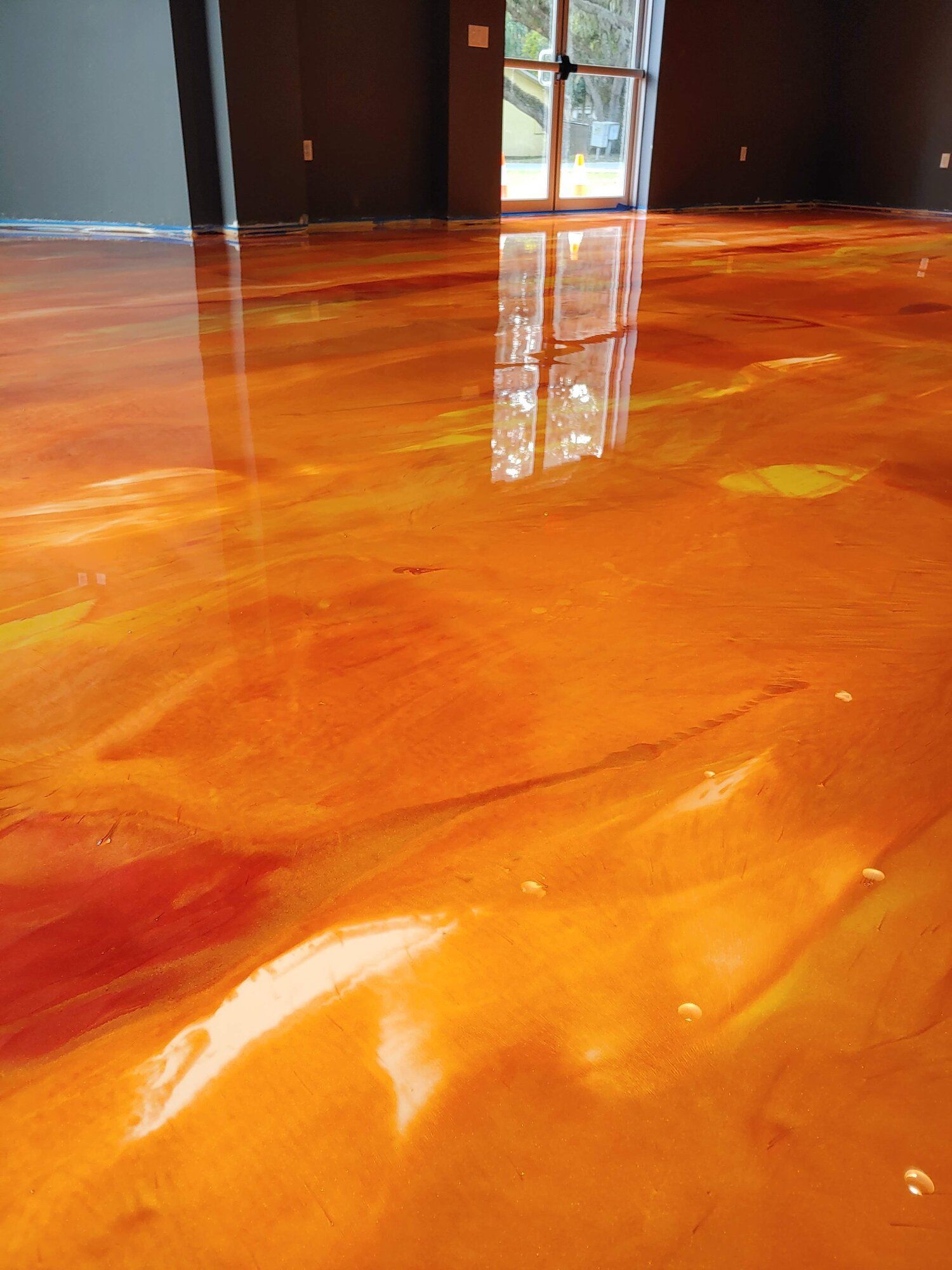 Shiny orange floor reflecting light in a dim room near a doorway