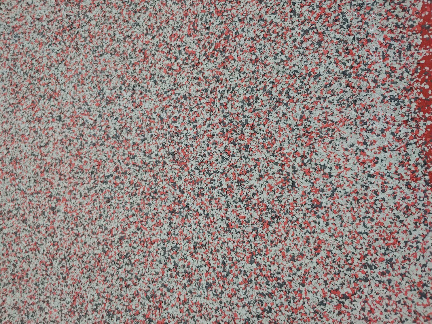 Abstract red, gray, and black speckled texture filling the frame, with a darker vertical edge on the right.