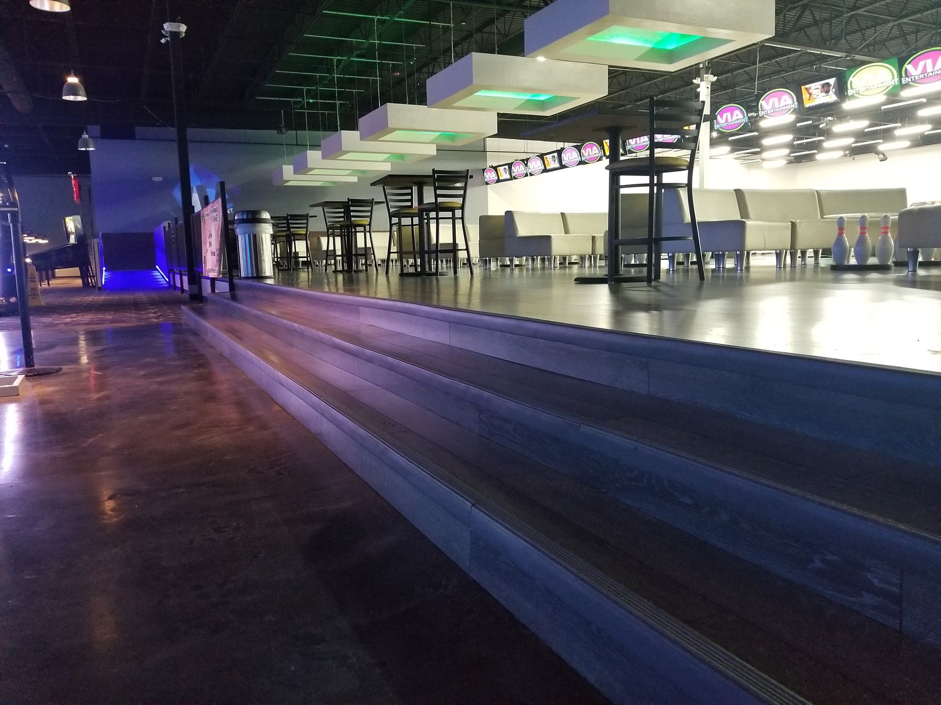 Empty airport terminal with bright overhead lights and a glossy floor at night
