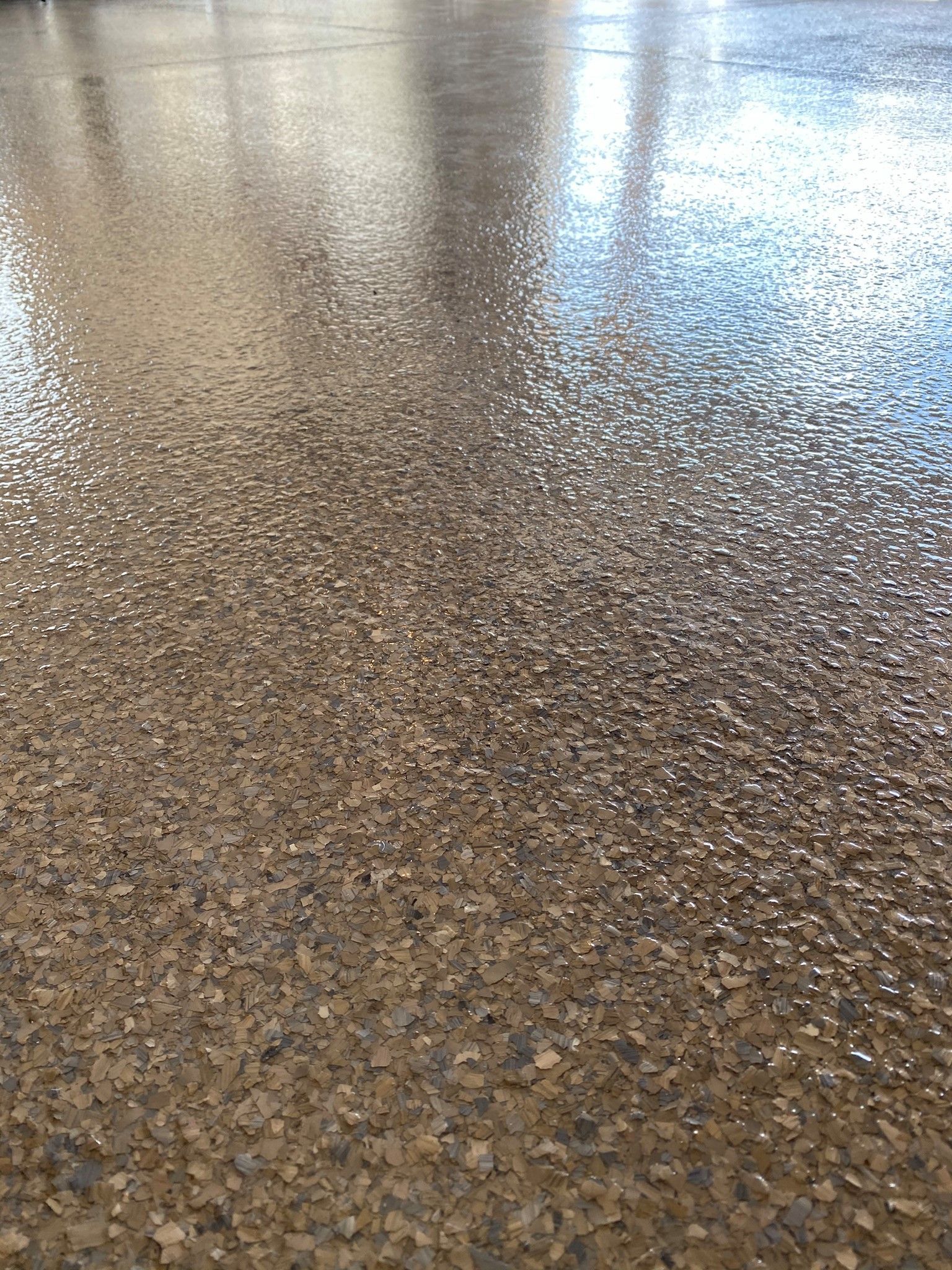 Glossy speckled terrazzo floor with bright reflections of light and windows