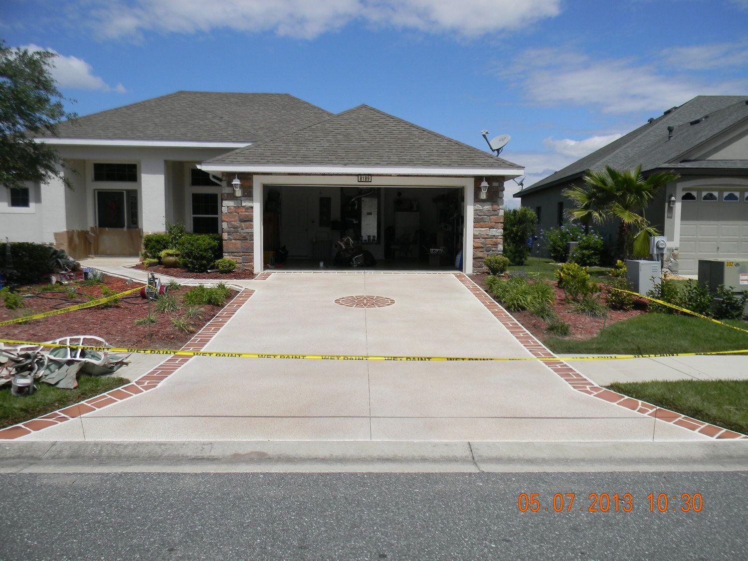 Suburban house with a driveway and front lawn under a blue sky