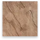 Close-up of tan, cracked rock or plaster surface with fine dark veins