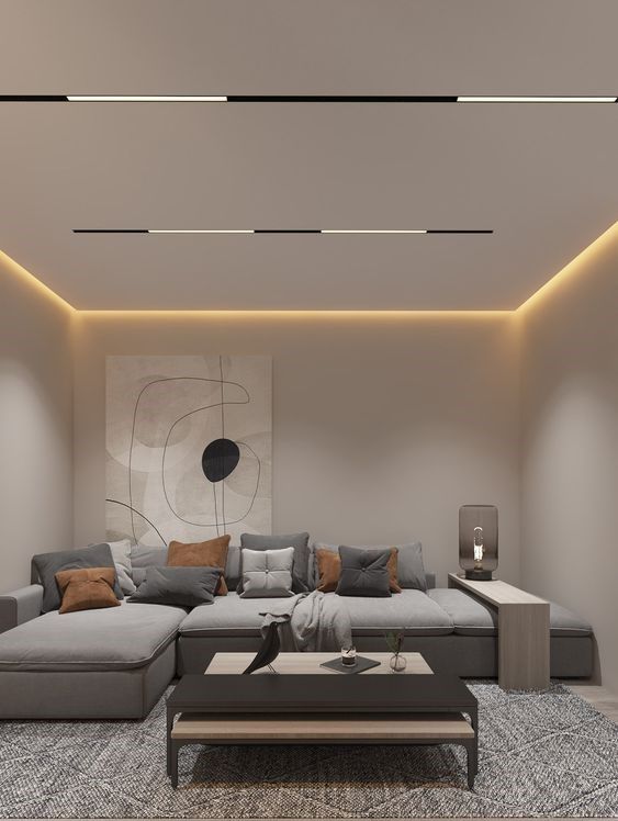 Modern bedroom with recessed ceiling lighting and abstract art above a bed with layered pillows