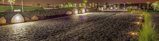 Katara Hills at night with illuminated pathways, landscaped greenery, and modern lighting.