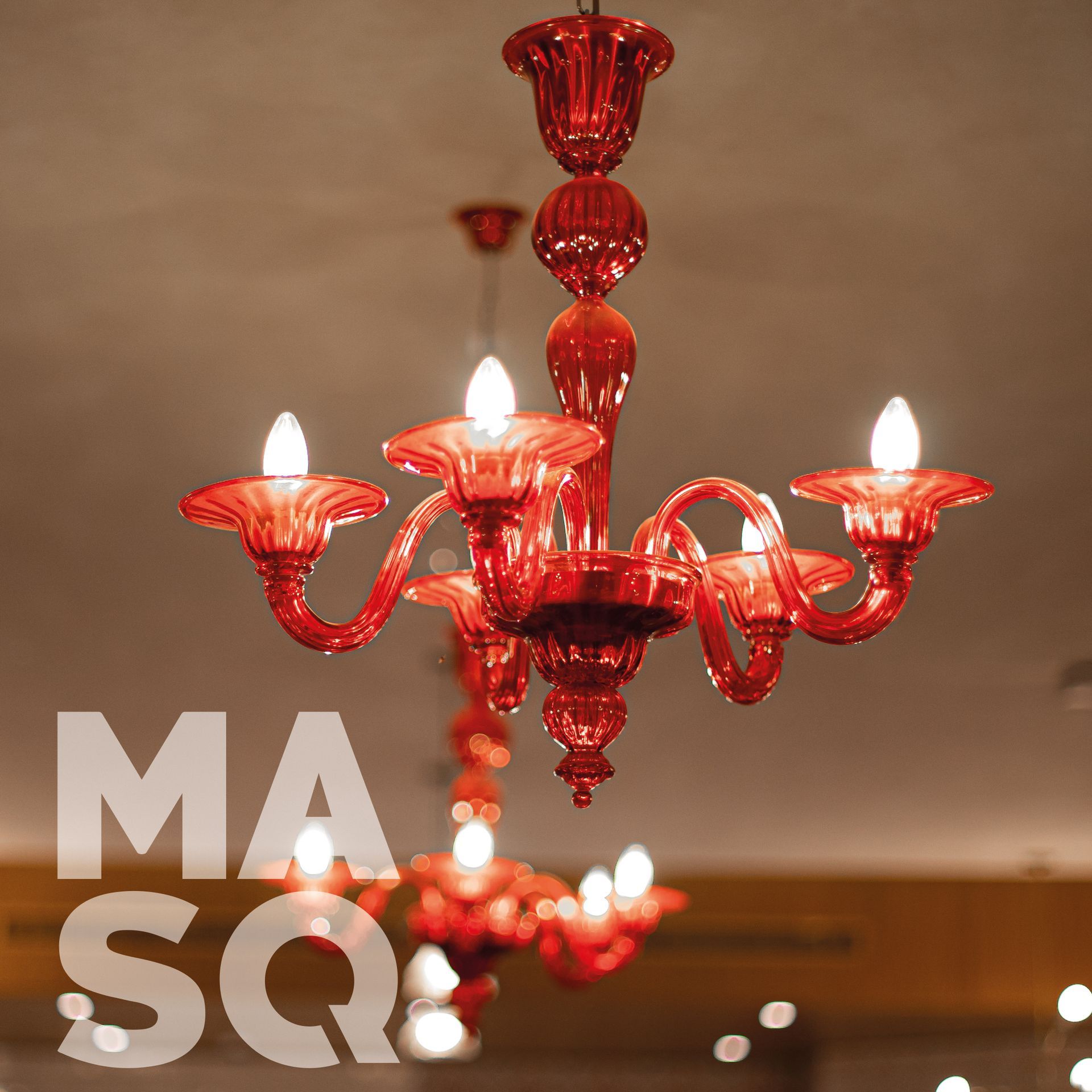 Elegant red glass chandelier with multiple glowing bulbs, adding a touch of luxury to the restaurant ambiance.