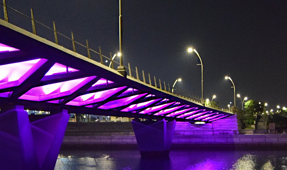 Lusail Bridge illuminated with vibrant purple lighting, showcasing its modern design and infrastructure at night.