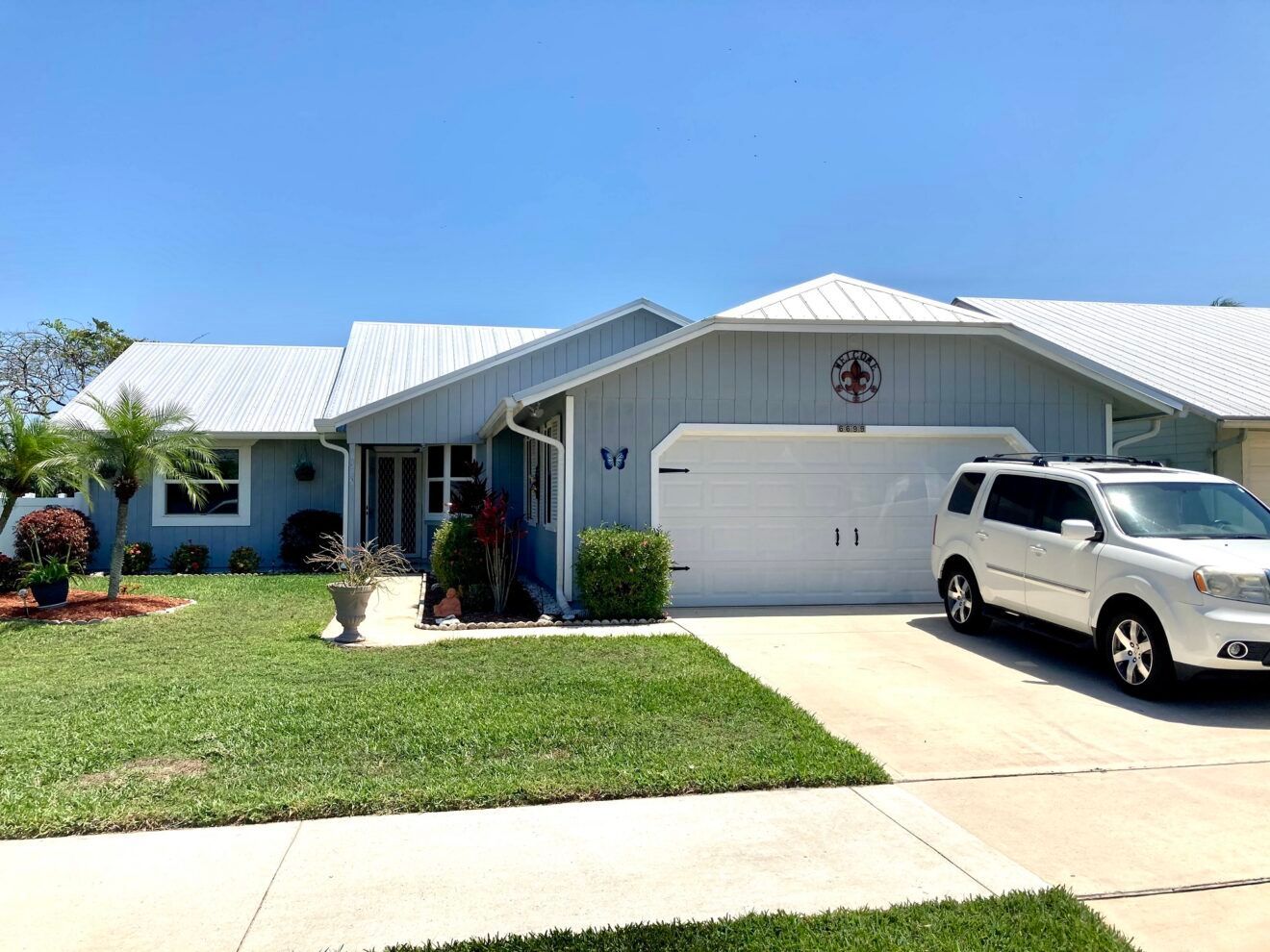 A white suv is parked in front of a house