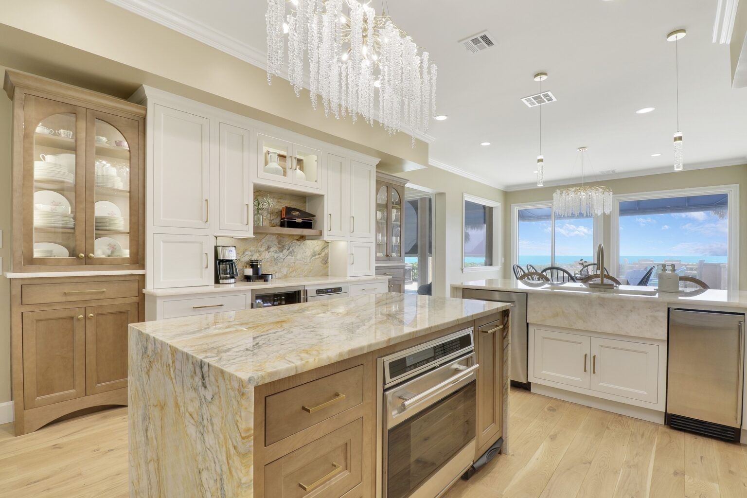 A kitchen with a large island and a chandelier hanging from the ceiling.