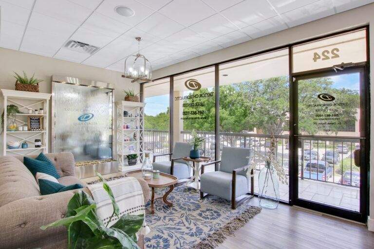 A living room with a couch , chairs , tables and a balcony.
