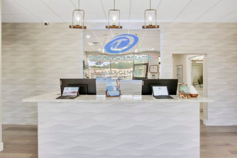A reception desk in a dental office with two laptops on it.