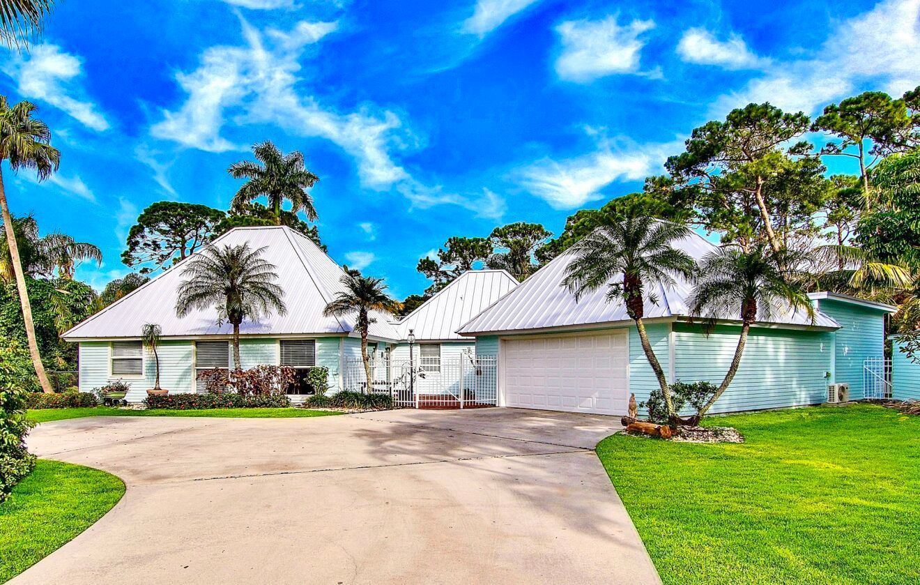 A large white house with palm trees in front of it