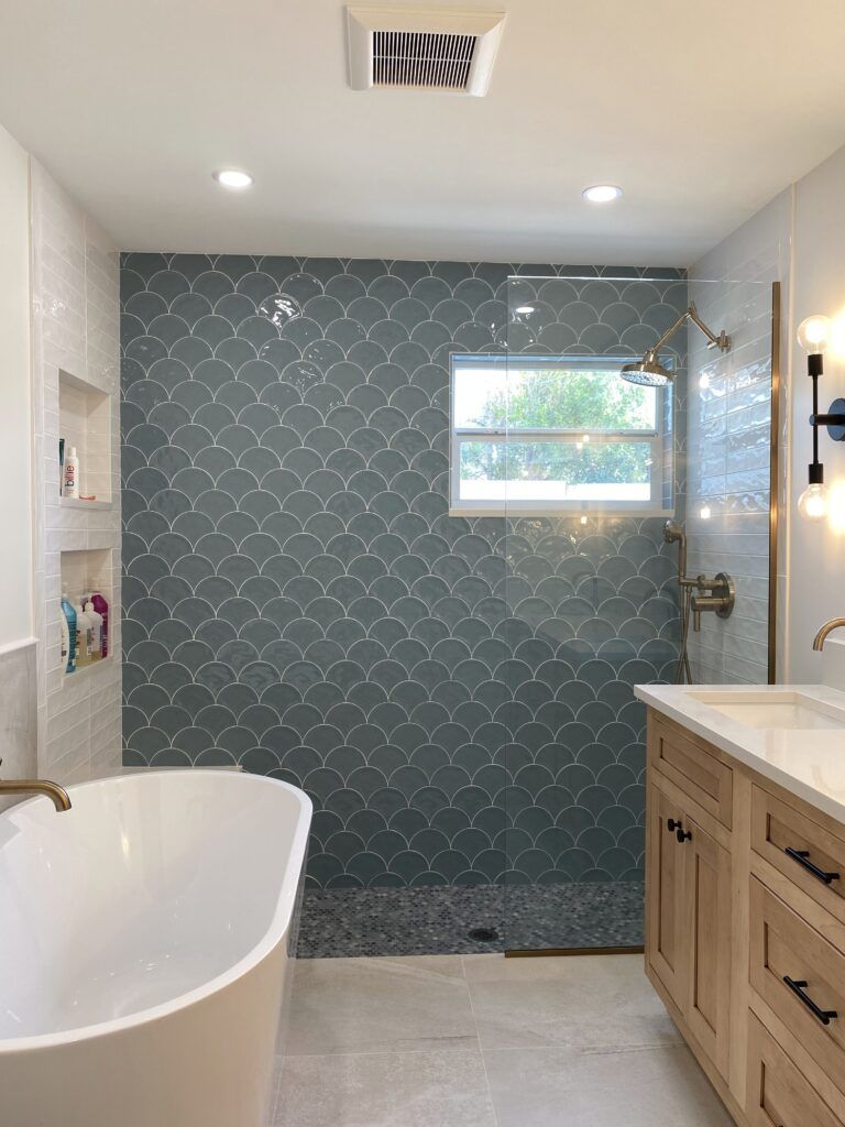 A bathroom with a bathtub , sink and shower.