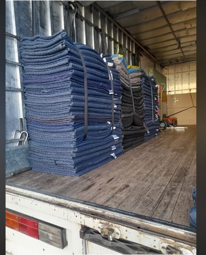Stacked blue and gray woven mats loaded inside a truck trailer — TJ Removals and Storage in Wagga Wagga, NSW