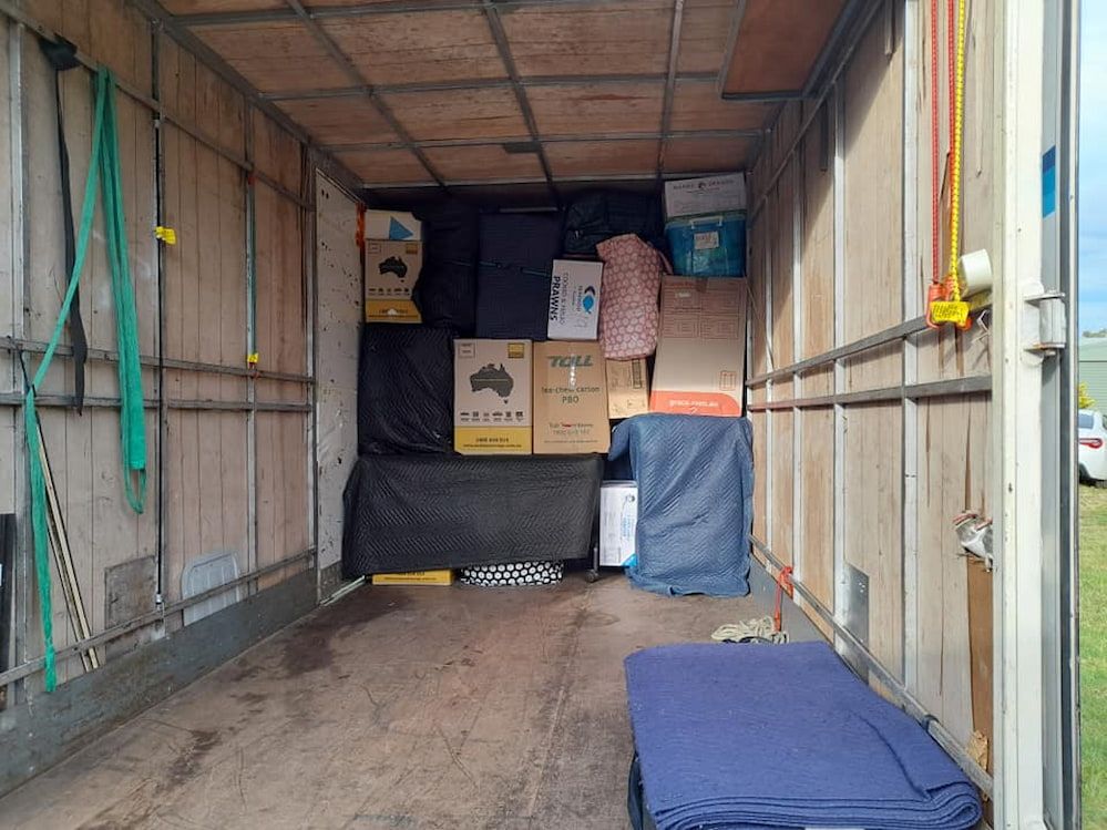 Two Men Are Loading Boxes Into a Truck — TJ Removals and Storage in Wagga Wagga, NSW