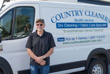 Country Cleaners delivery driver standing beside the company pickup and delivery van