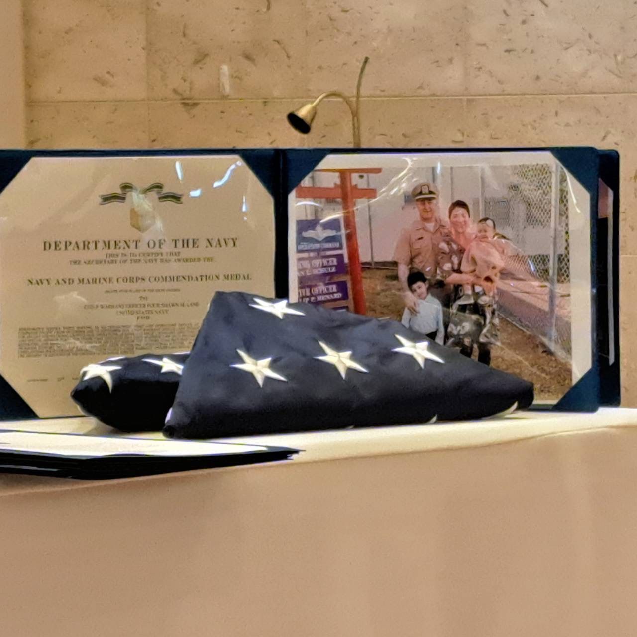 “Country Cleaners veteran owner’s Navy retirement flag, Navy commendation, and family photo.”