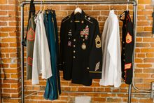 Military and professional uniforms hanging on a clothing rack