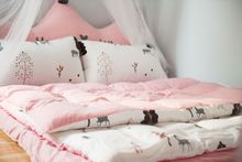 Pink and white bedding with pillows, comforter, and quilt