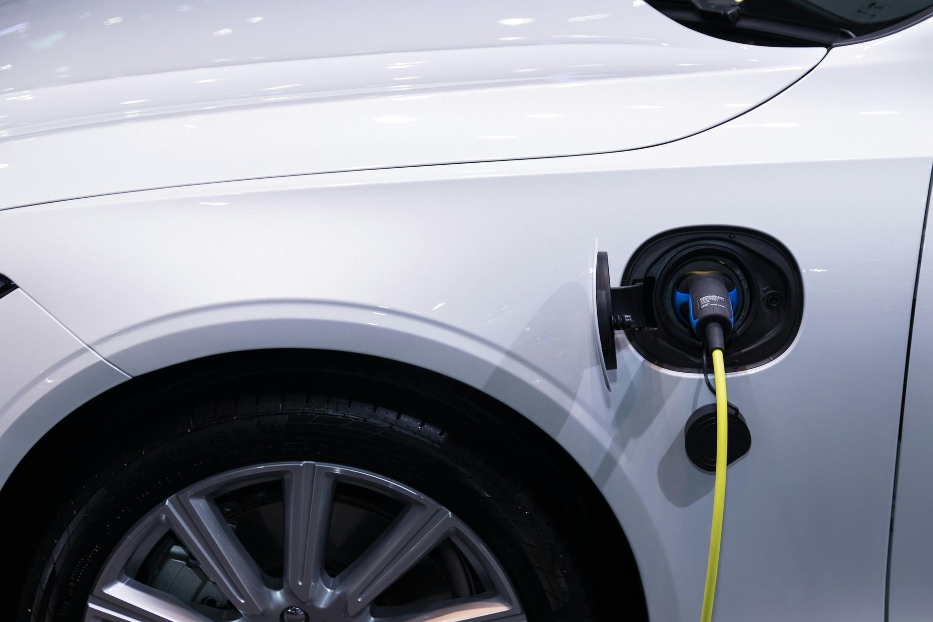 Ein weißes Auto ist an einer Ladestation an der hinteren Seitenwand angeschlossen.