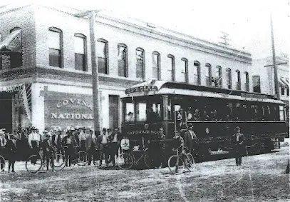 Tree Service Elmonte-Historic black and white photo of a bustling street scene with a trolley car labeled