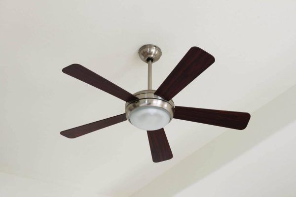 Dark ceiling fan with five blades mounted on a white ceiling