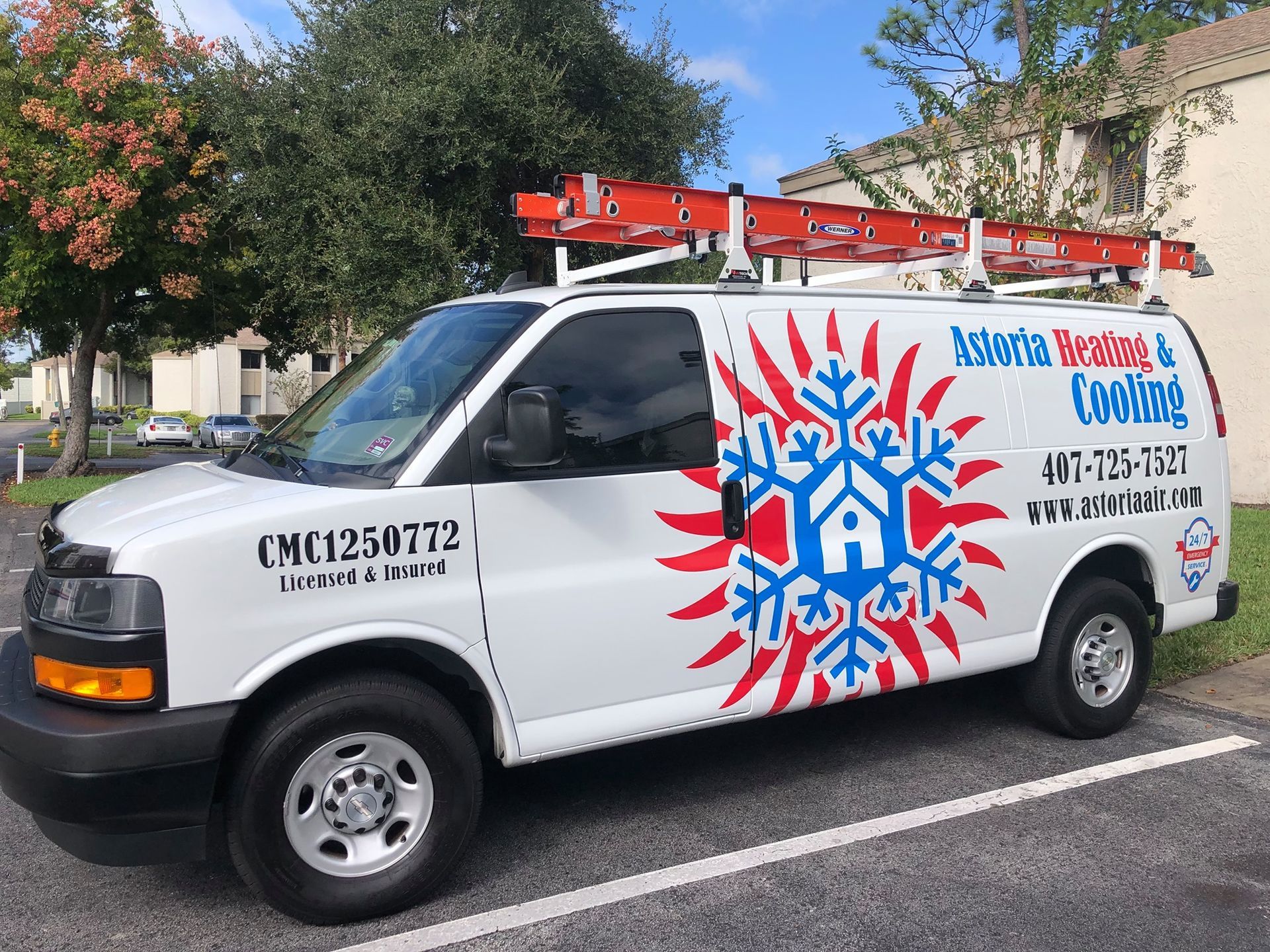 White HVAC work van featuring a snowflake and sun logo, company name, phone number, and a roof ladder in a parking lot.