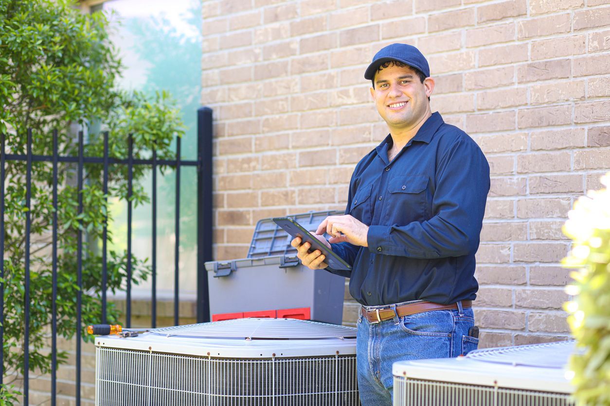a man is standing in front of a brick building holding a tablet .