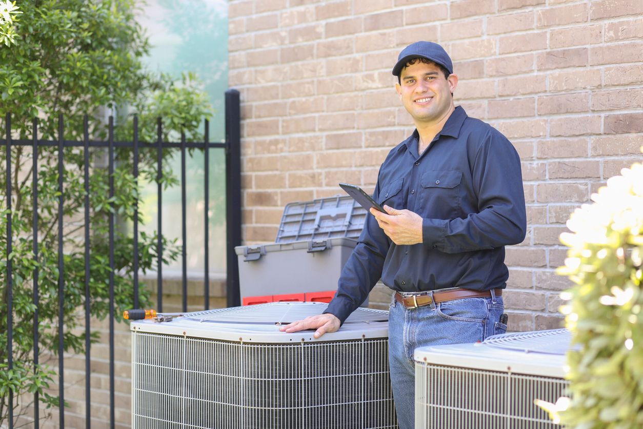a man is standing next to two air conditioners in front of a brick building .
