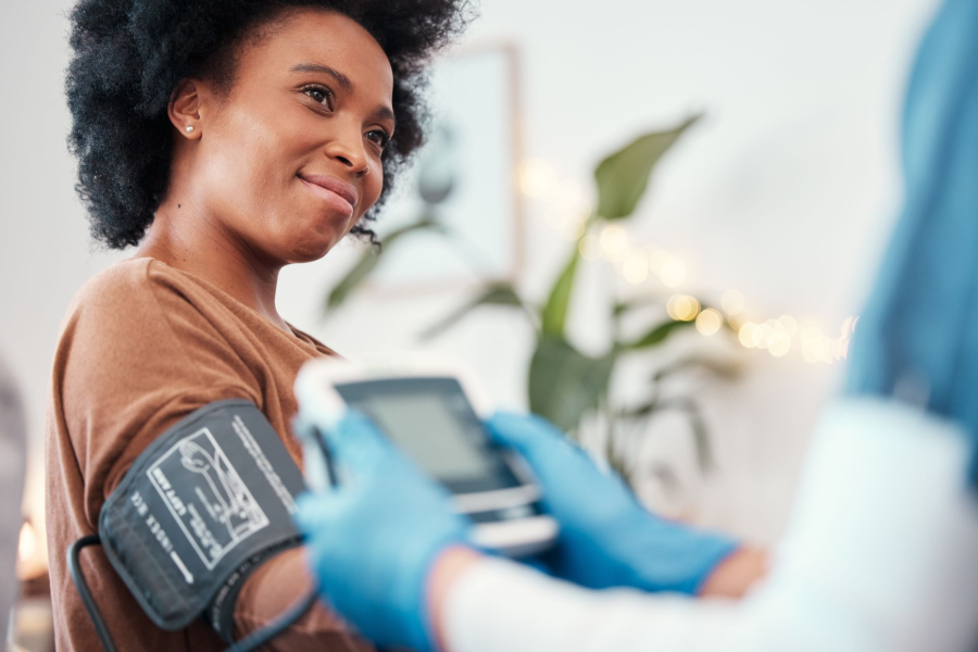 Person having blood pressure checked by a clinician in a bright clinic