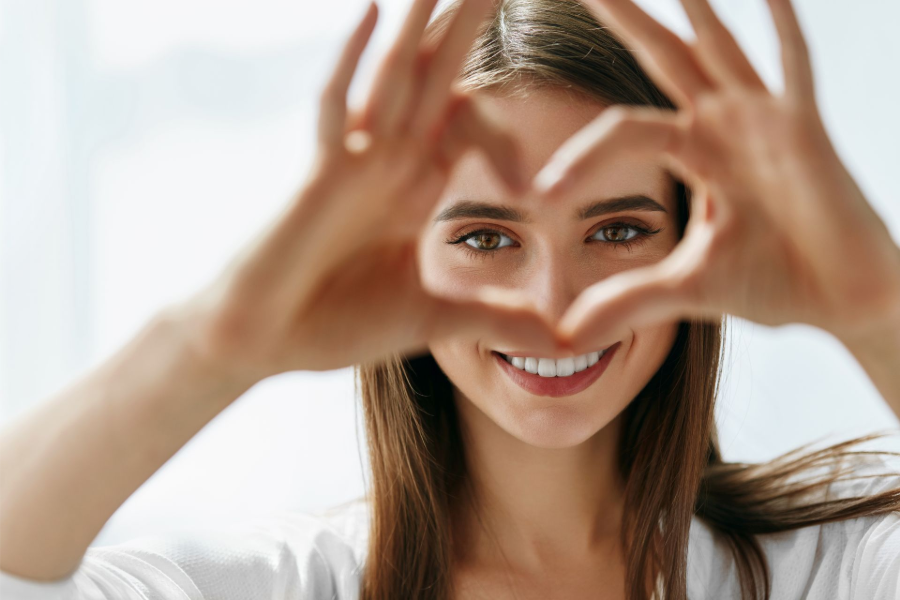 A woman holding up her hands to form a heart.