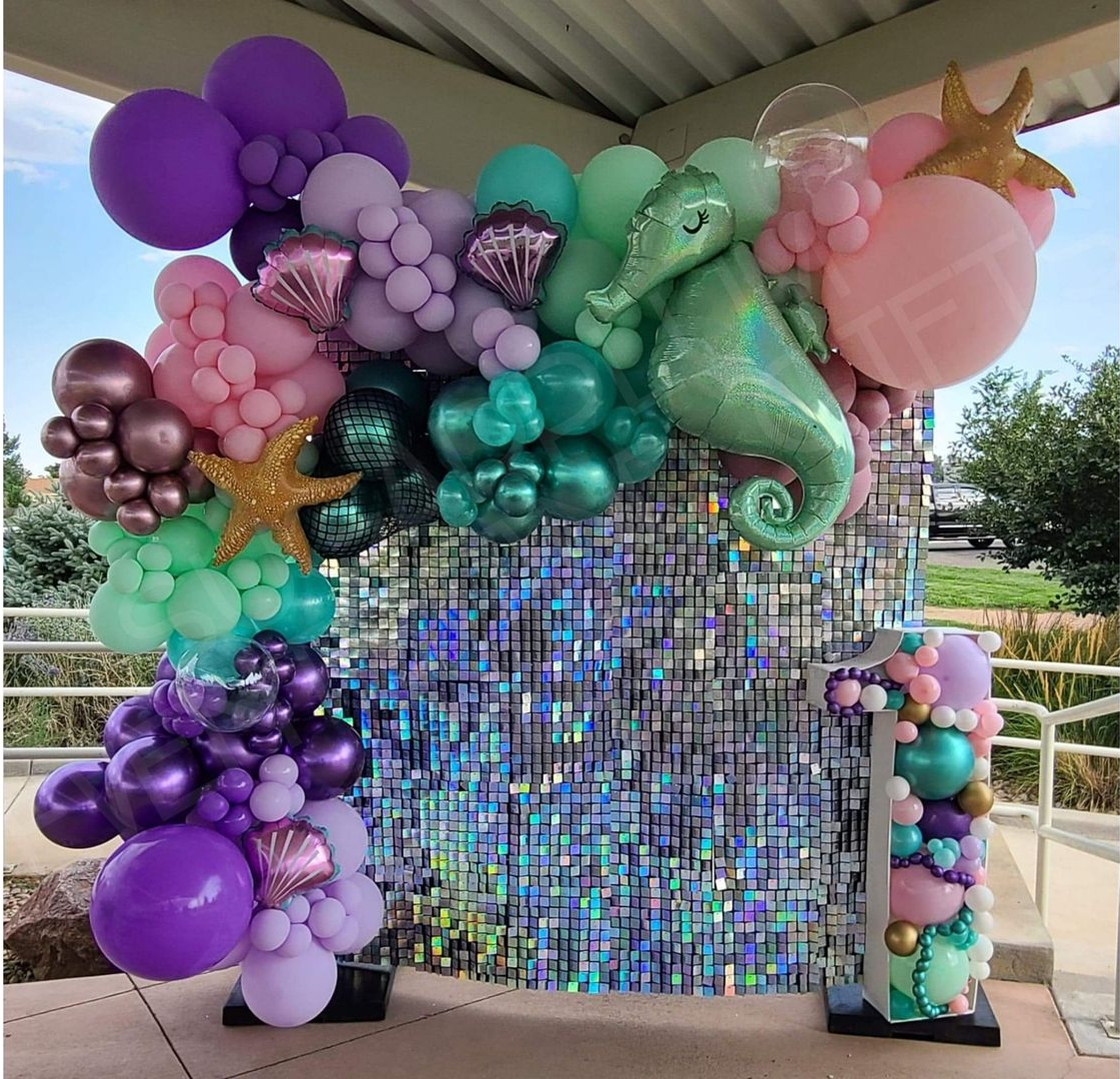 Pastel balloon arch with mermaid and sequin backdrop for a party photo display