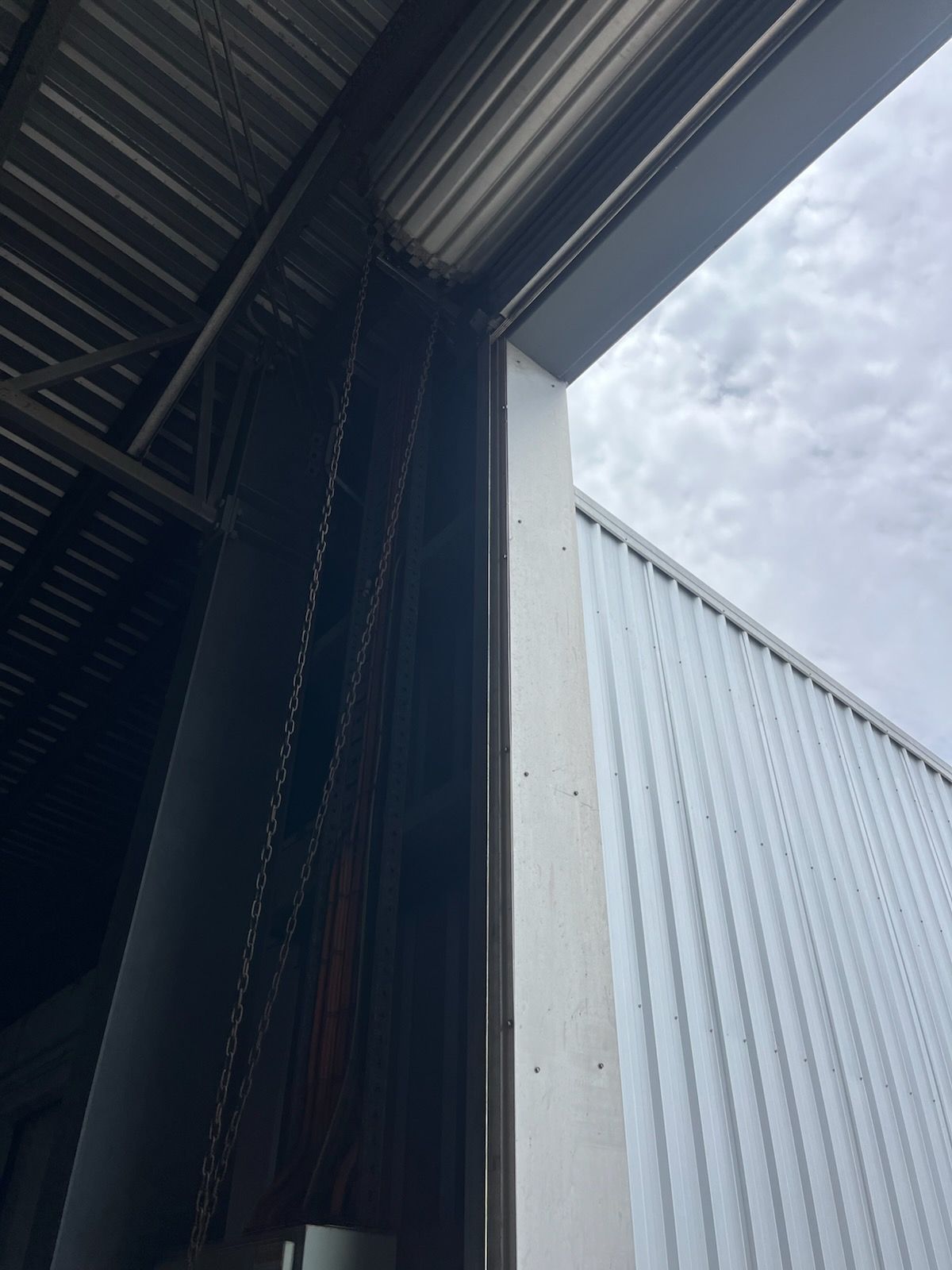 Interior view of a metal warehouse doorway with corrugated roof and cloudy sky outside — Rolling With Netherpoel in Airlie Beach, QLD