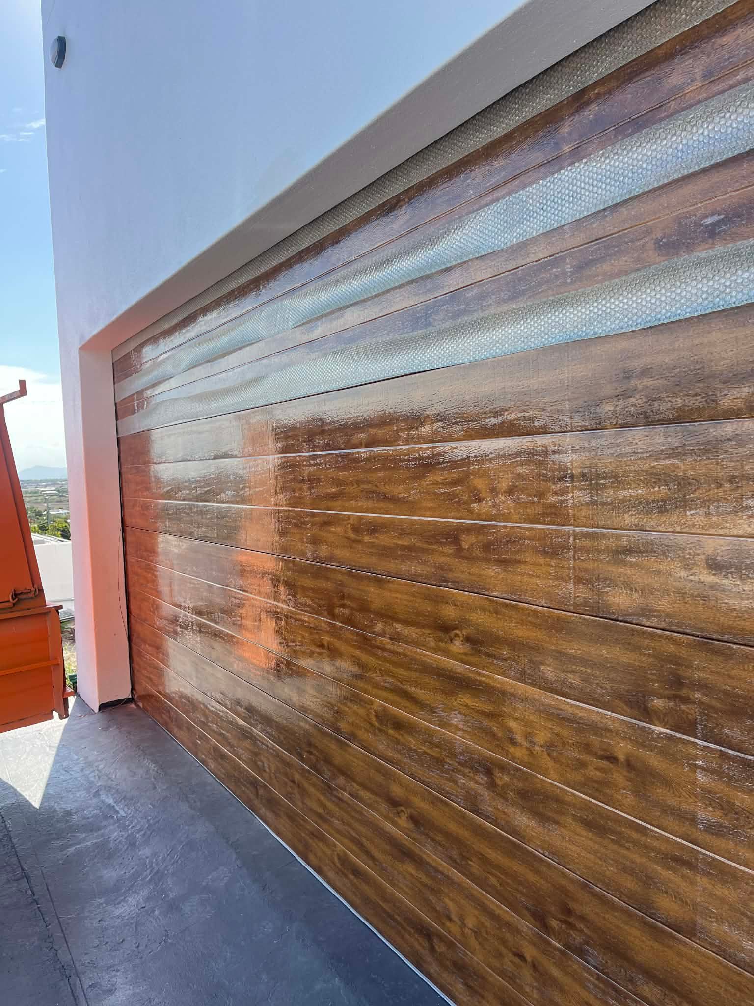 Closed Brown Garage Door on a Brick House Exterior — Rolling With Netherpoel in Airlie Beach, QLD