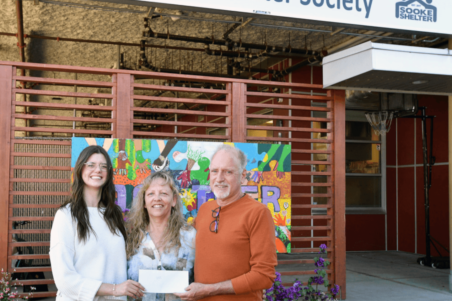 Dr. Chris Bryant presenting cheque $582 to Sooke Shelter Society executive director, Sherry Thompson (centre) and Katie (shelter staff).