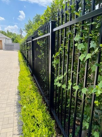 Wooden privacy fence along a narrow backyard with dry grass and an air conditioner unit on the right.