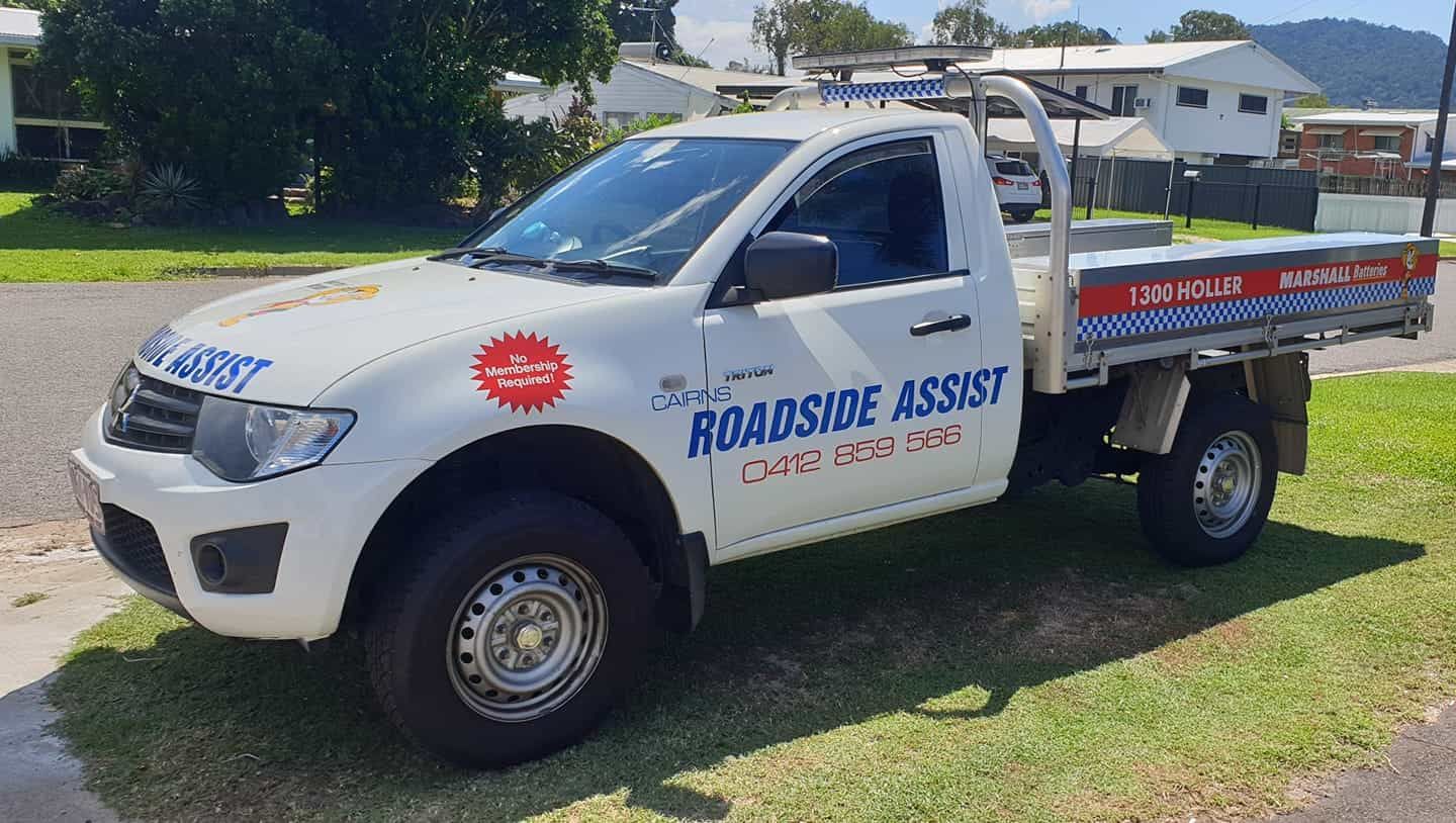 A white truck with a flat bed is parked on the side of the road — Cairns Roadside Assist In Manunda, QLD