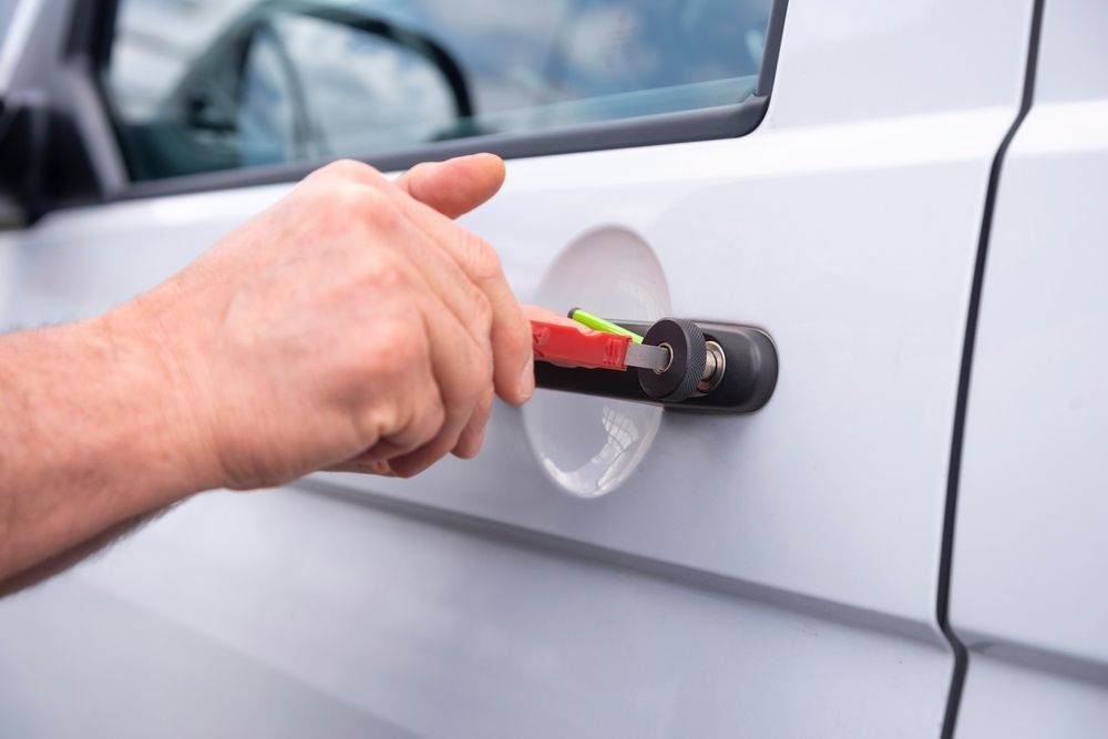 A Person Is Opening The Door Of A White Van With A Wrench — Cairns Roadside Assist In Cairns, QLD