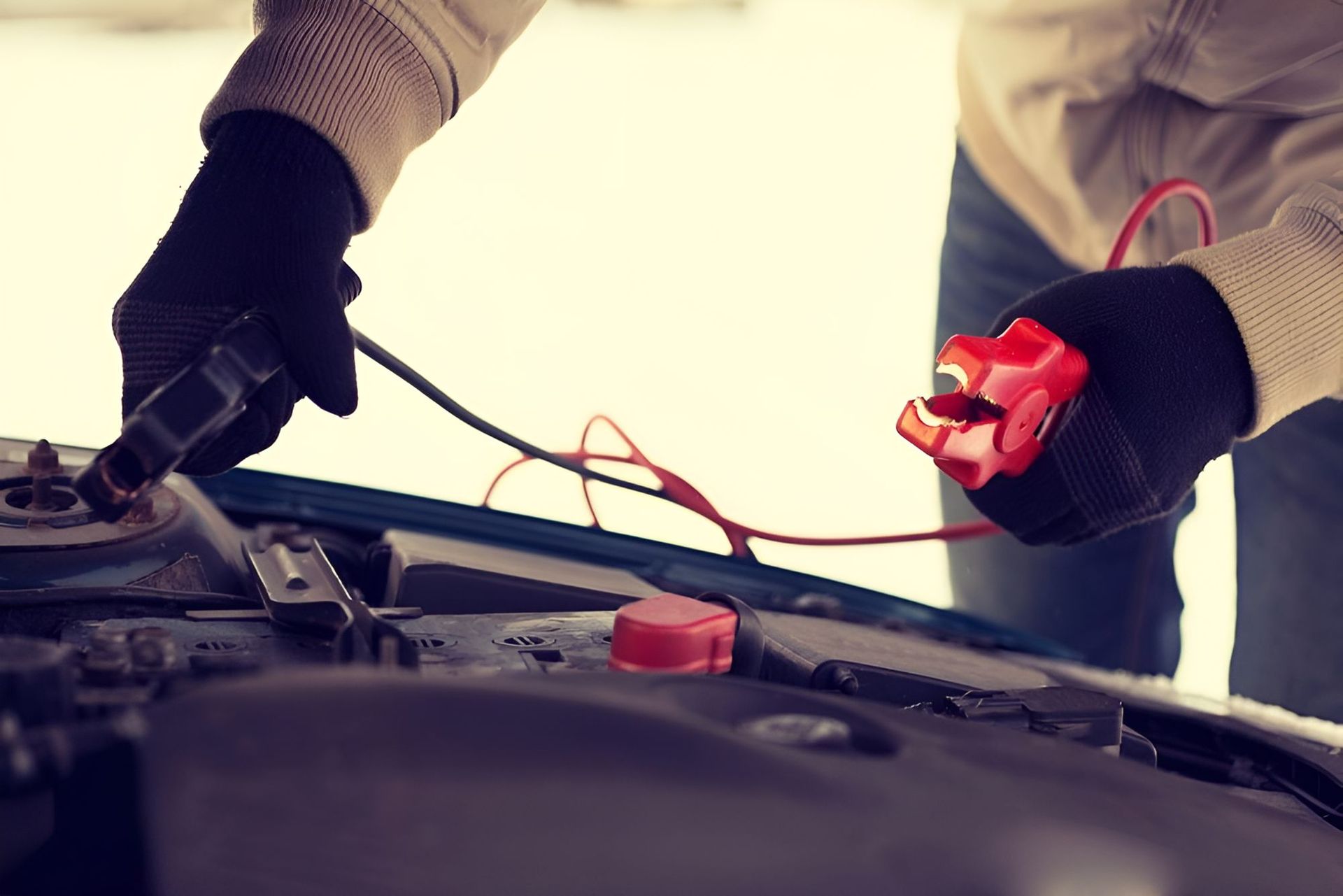 A Person Is Charging A Car Battery With A Jump Starter — Cairns Roadside Assist In Innisfail, QLD