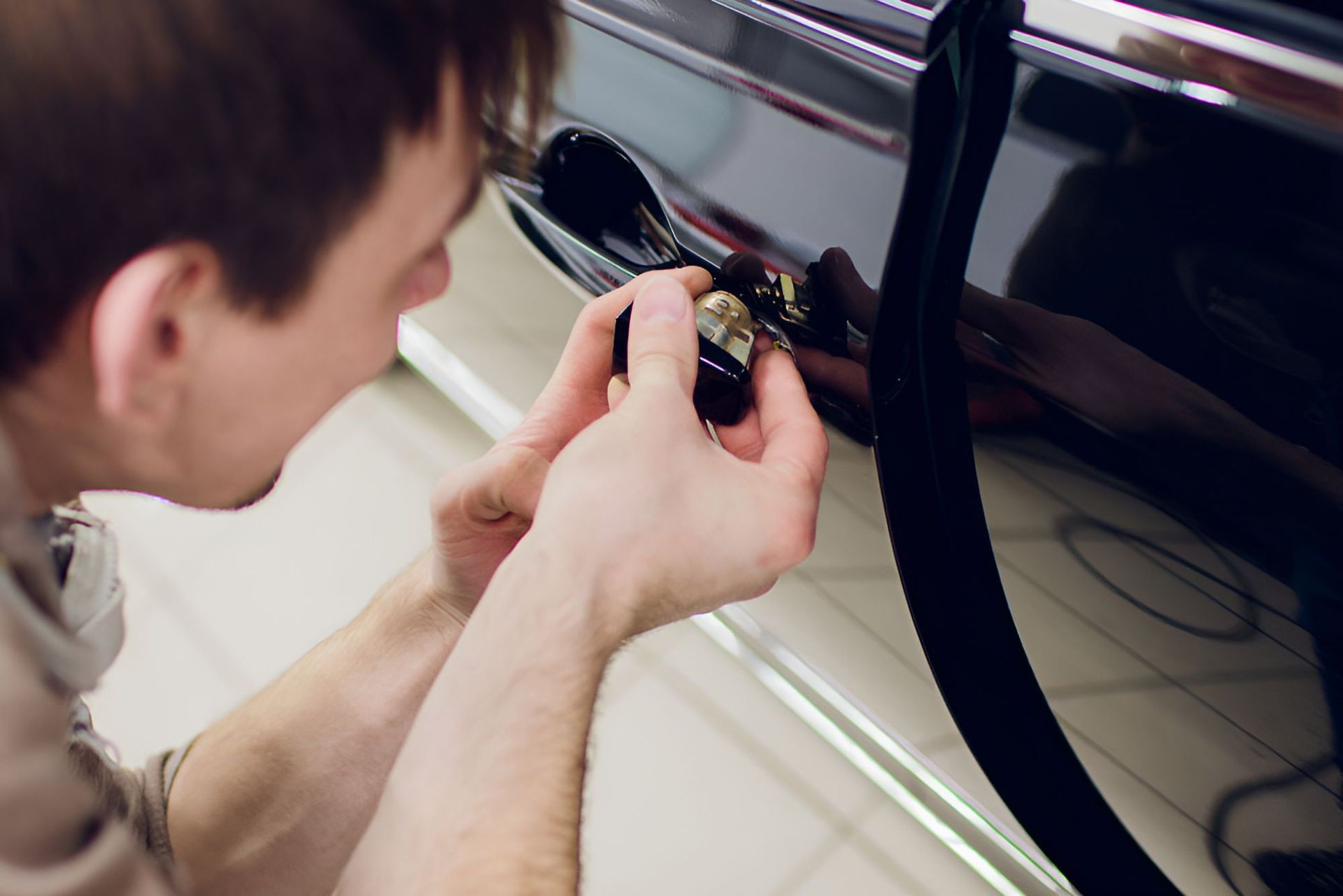 A Man Is Fixing A Car Door With A Screwdriver β Cairns Roadside Assist In Manunda, QLD