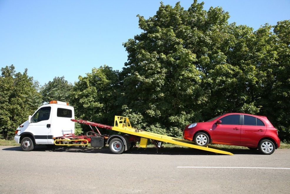 A Red Car Is Being Towed By A Tow Truck — Cairns Roadside Assist In Port Douglas, QLD