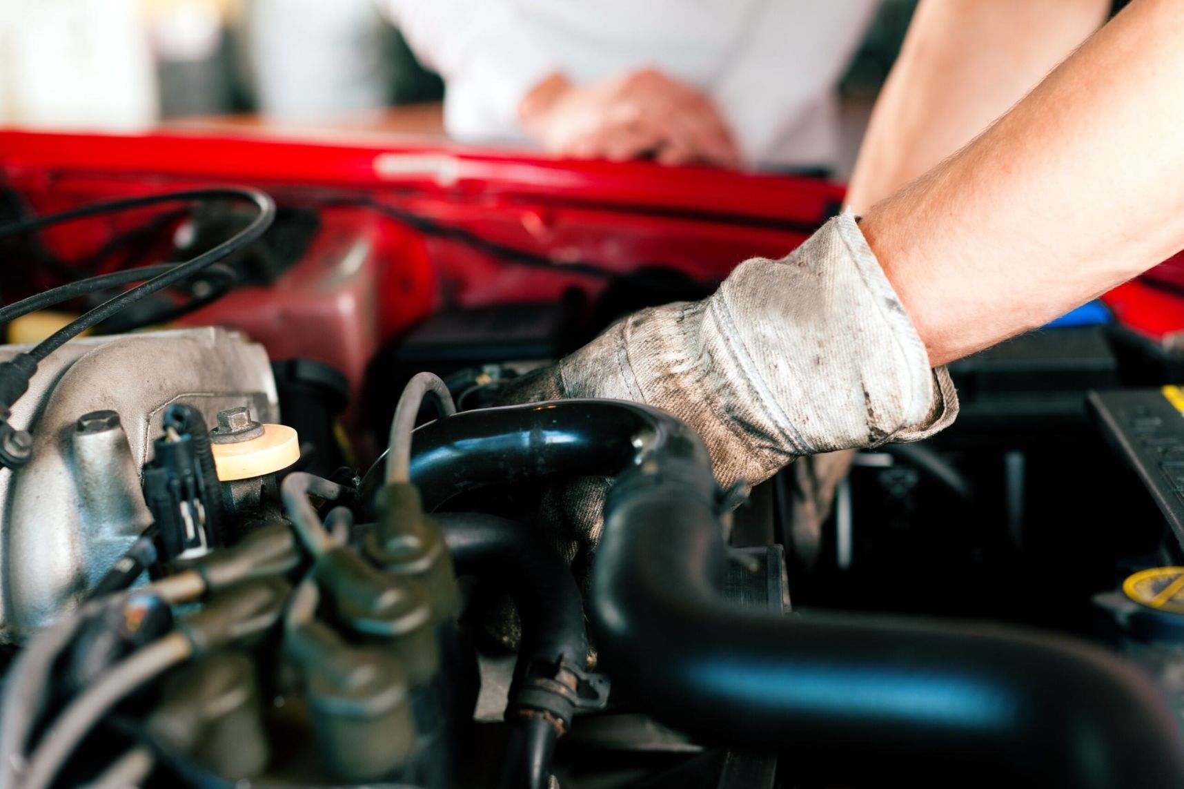 A Man Is Working On The Engine Of A Red Car — Cairns Roadside Assist In Port Douglas, QLD
