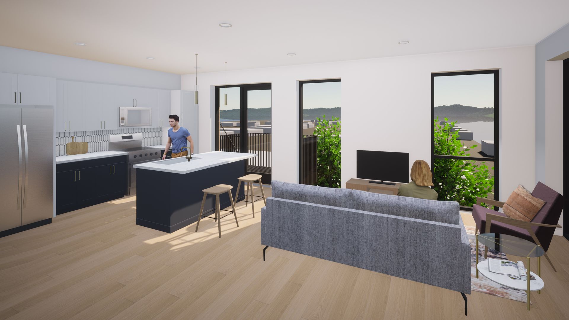 Modern open-plan living space with kitchen, island, living area, large windows, and a person standing near the stove.