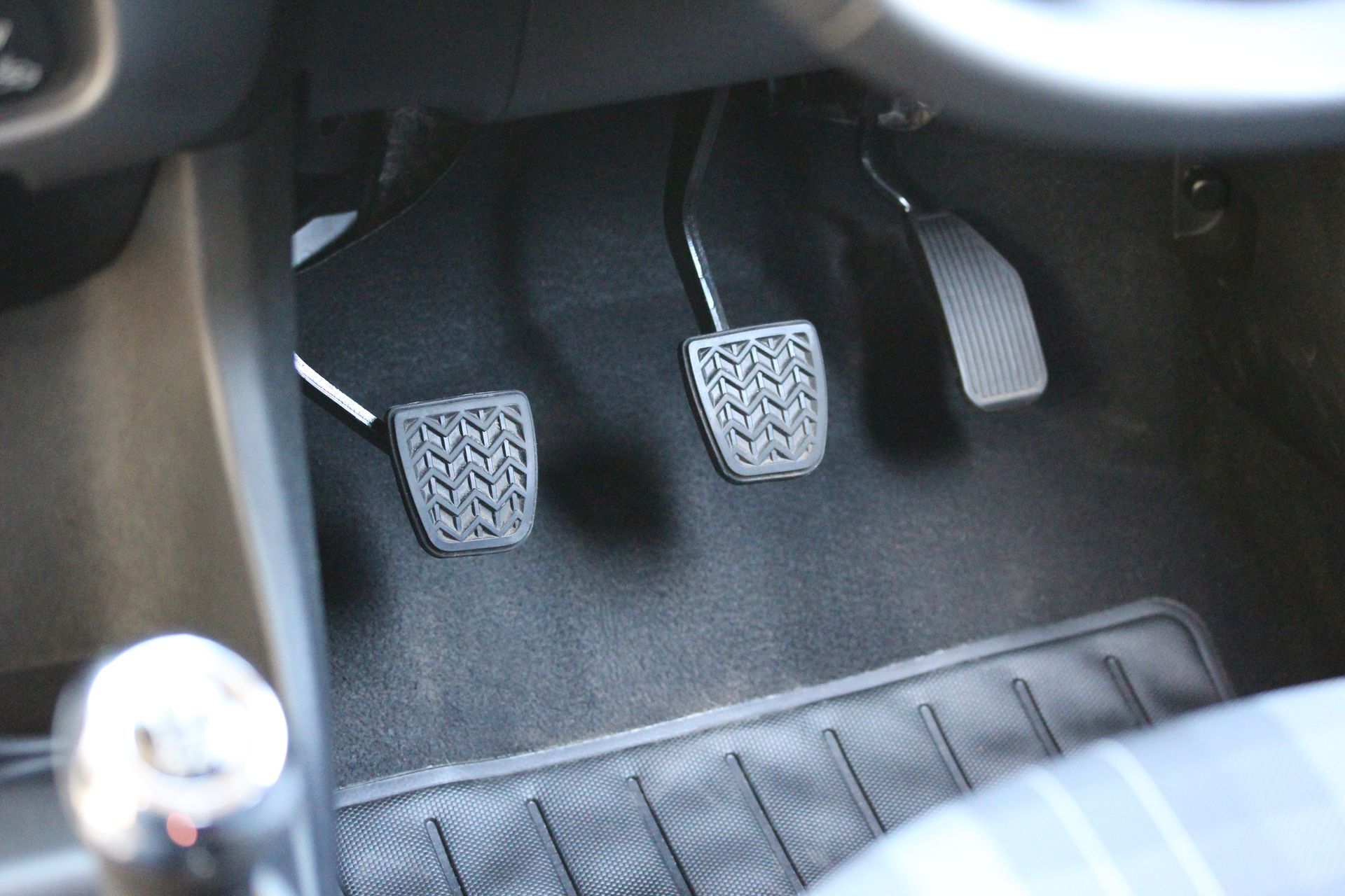 Car pedals in a vehicle footwell, including clutch, brake, and accelerator. Car pedals in a vehicle footwell, including clutch, brake, and accelerator.