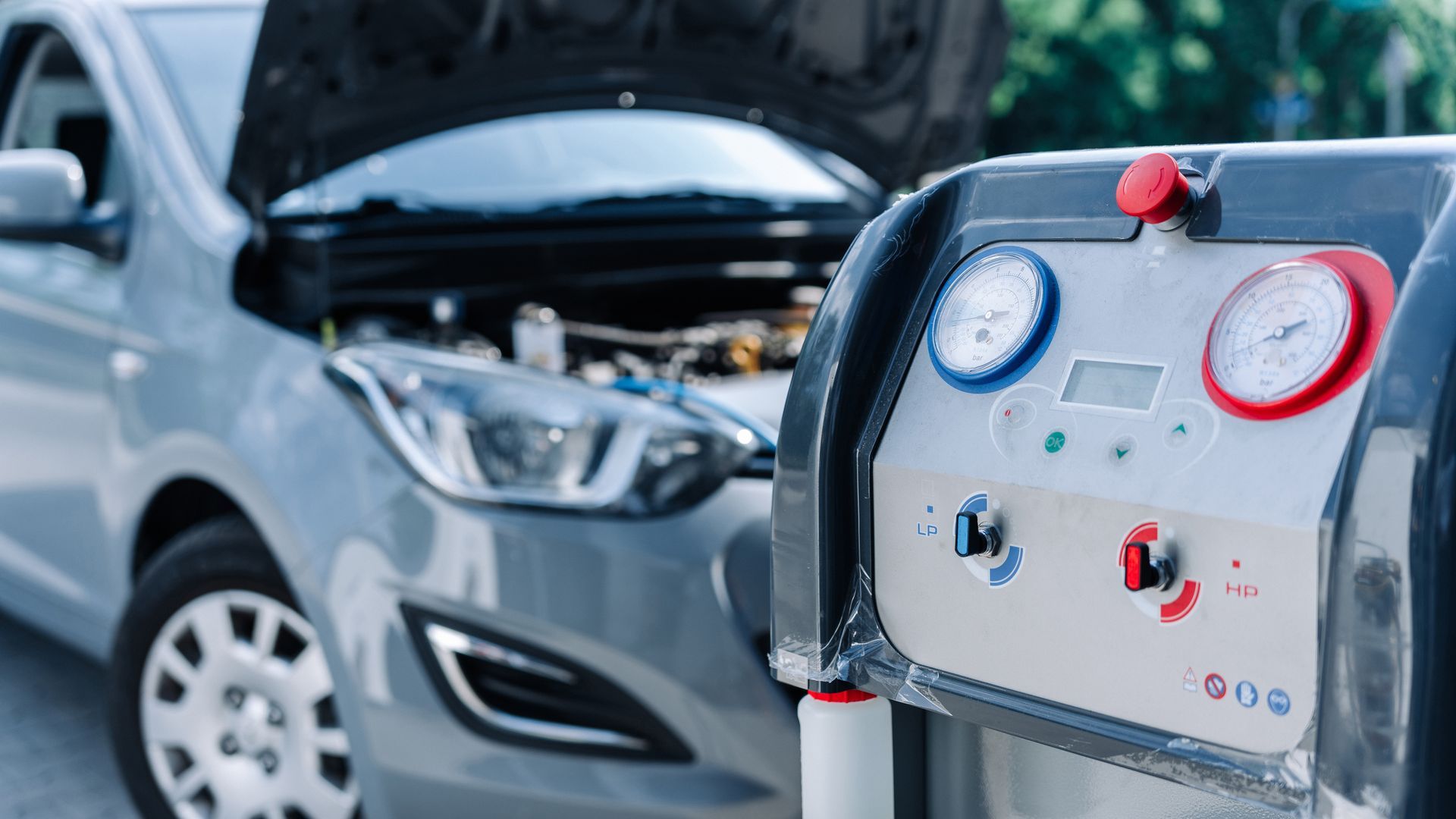 Electric car charging with hood open and charging station in foreground