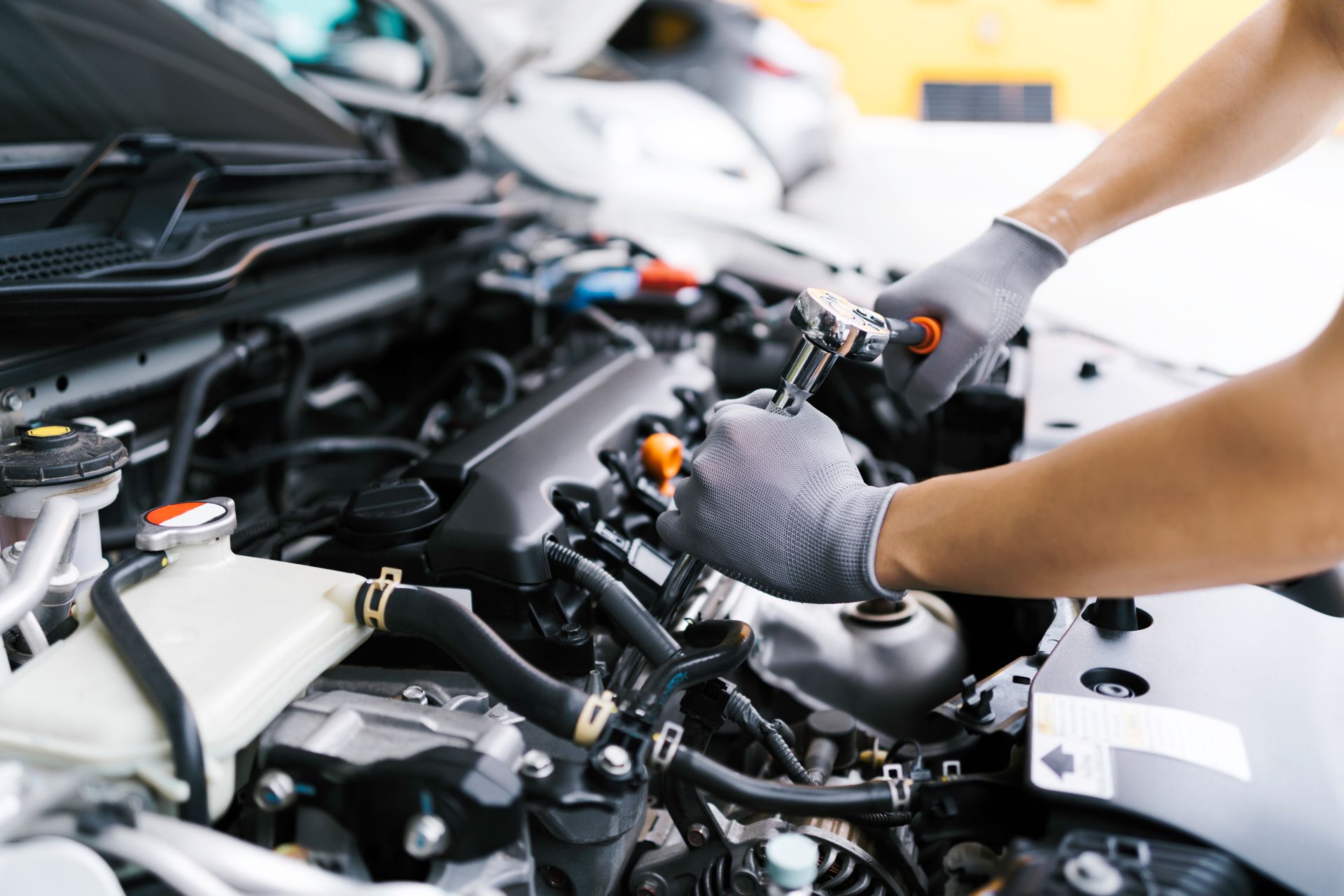 Mechanic working on a car engine in an auto repair shop Mechanic working on a car engine in an auto repair shop
