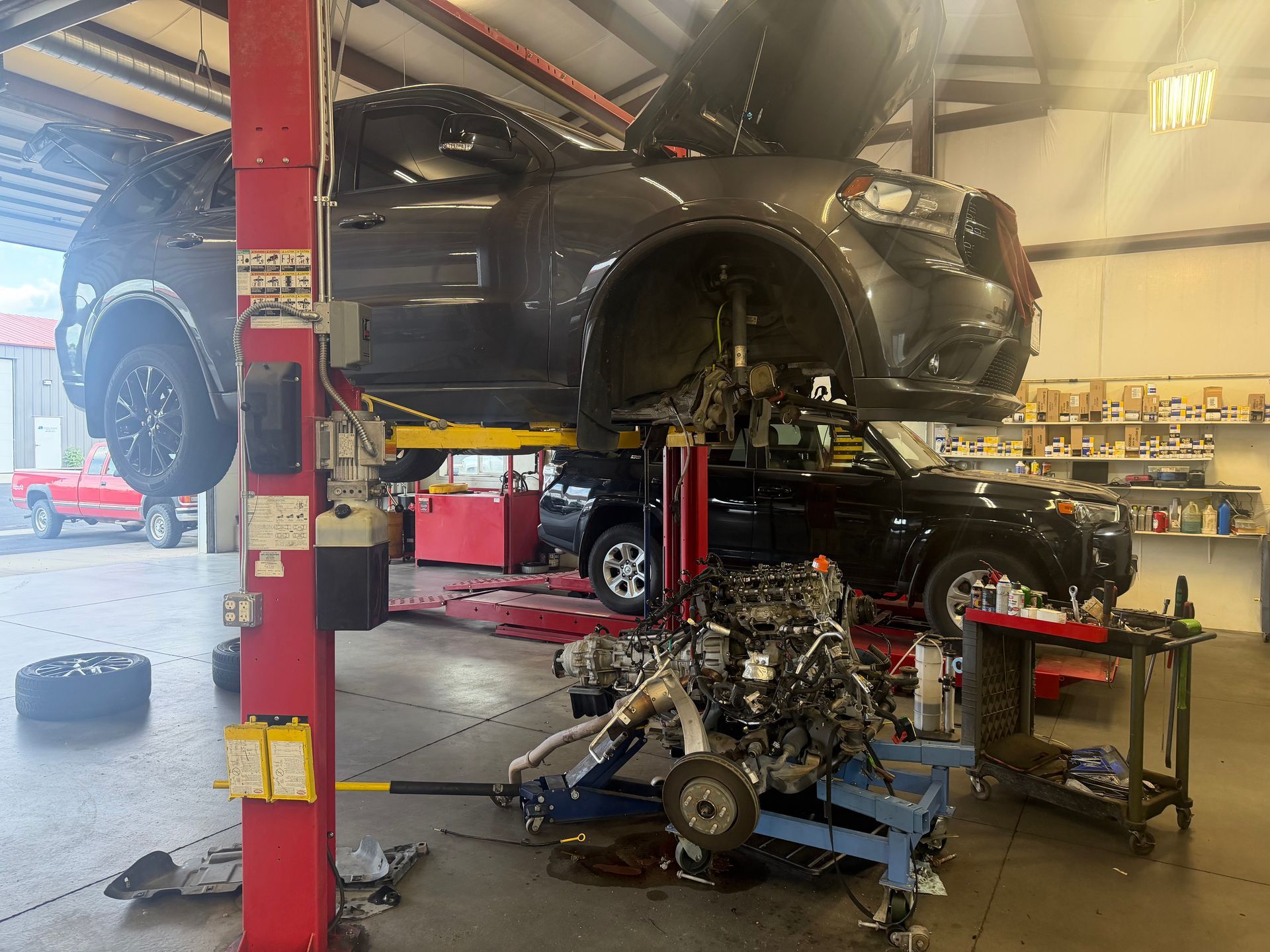 Mechanic in gray gloves inspecting car engine under the hood in a repair shop Mechanic in gray gloves inspecting car engine under the hood in a repair shop