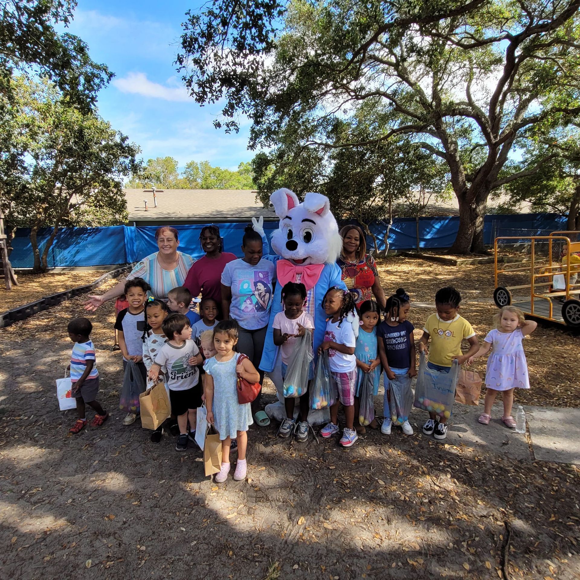 A group of children are posing for a picture with an easter bunny mascot