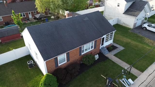An aerial view of a brick house with a black roof.